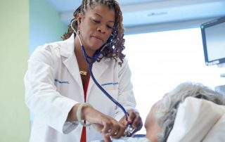 photo of doctor examining patient in hospital room