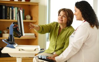 photo of doctor and patient meeting at computer