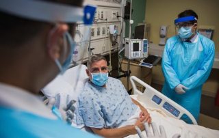 photo of patient and doctors in hospital setting