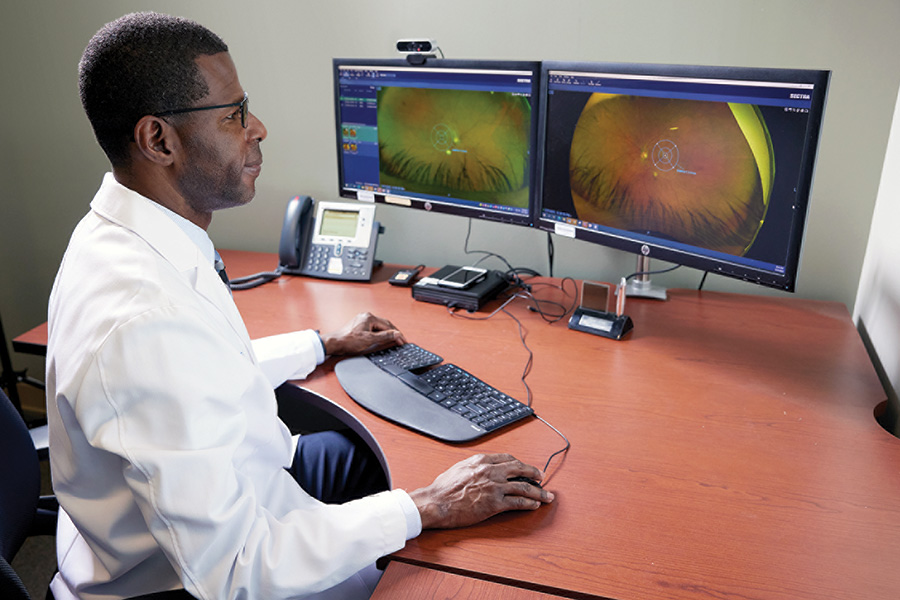 Dr. Erold Jean-François reviews a patient’s retinal scan to evaluate the progression of diabetic retinopathy.