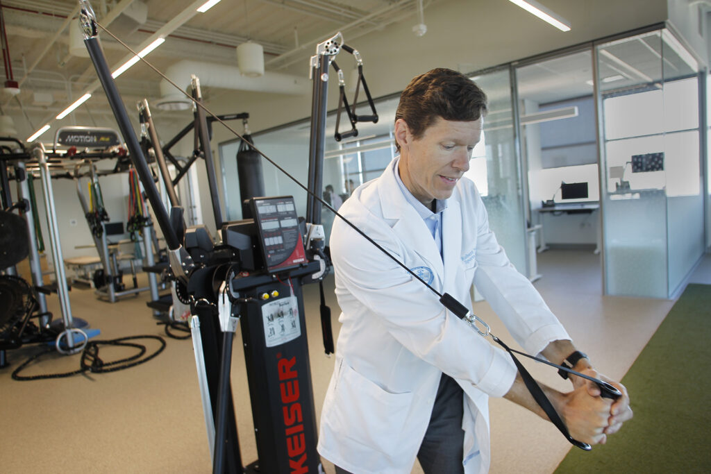 Robert Nied, MD, demonstrating some equipment at the Kaiser Permanente Mission Bay Medical Offices sports medicine center.