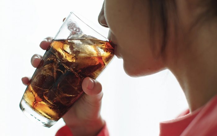 Close-up of young woman drinking cold drink.